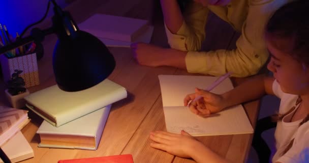 Angry mother scolding her little daughter for mistake in homework late in evening - Footage, Video