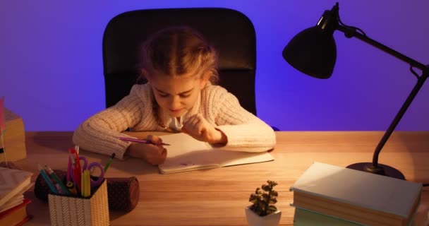 Petite écolière stressée faisant ses devoirs tard dans la soirée - Séquence, vidéo