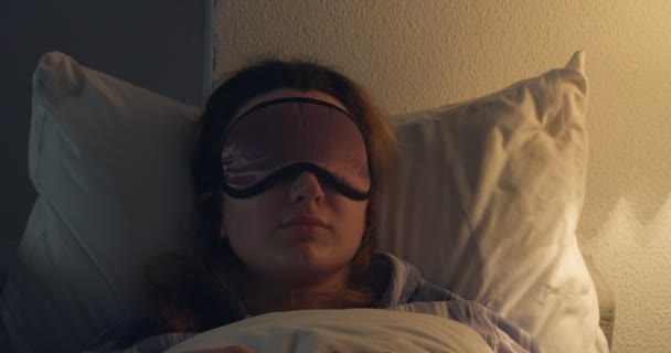 Mujer joven durmiendo en la cama por la noche - Metraje, vídeo