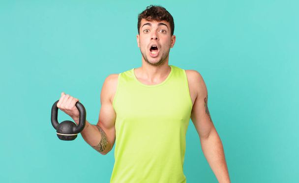 fitness man looking very shocked or surprised, staring with open mouth saying wow - Фото, изображение