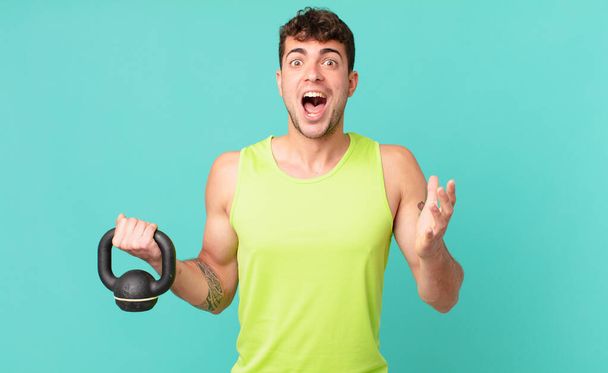 fitness man open-mouthed and amazed, shocked and astonished with an unbelievable surprise - Photo, Image