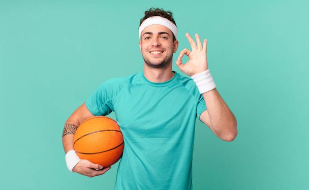 fitness man feeling happy, relaxed and satisfied, showing approval with okay gesture, smiling - Photo, image