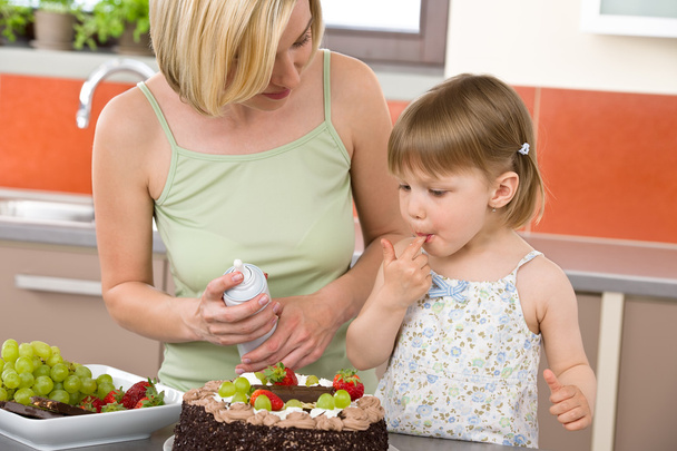 Mother and child with chocolate cake in modern kitchen - Foto, Imagem