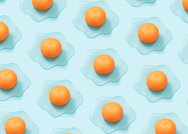 Kreatives sonniges Eiermuster aus frischer Mandarine und Schleim auf pastellblauem Hintergrund. Minimales veganes Frühstückskonzept. - Foto, Bild