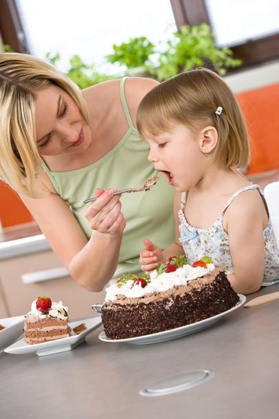 Mother and child tasting chocolate cake in kitchen - Foto, Imagem