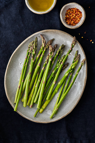 Asparagus on a plate. Fresh asparagus on a fabric background. - Foto, Bild