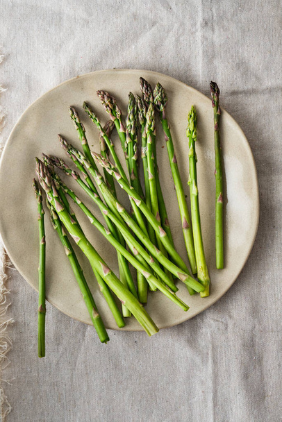Asparagus on a plate. Fresh asparagus on a fabric background. - Foto, Bild