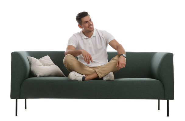 Man relaxing on comfortable green sofa against white background - Фото, зображення
