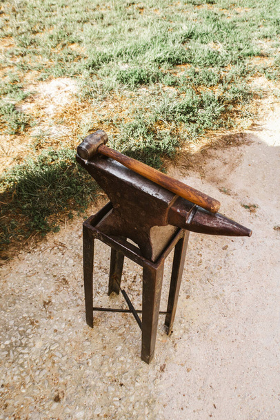 yunque y martillo de los herreros listos para el uso fuera en un camino de tierra - Foto, imagen