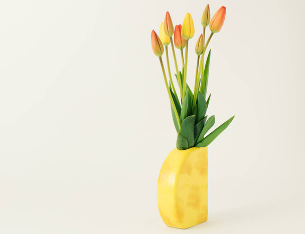 Creative spring concept made with reddish - yellow tulips on the white background. Easter and spring greeting card. - Photo, image