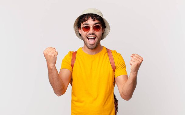 hispanic tourist man feeling shocked, excited and happy, laughing and celebrating success, saying wow! - Valokuva, kuva