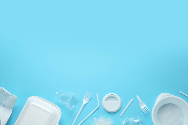 Plastic dishware on light blue background, flat lay. Space for text - Foto, Bild