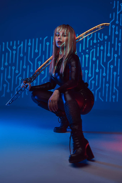 Cyberpunk style woman assassin with glowing sword - Photo, Image
