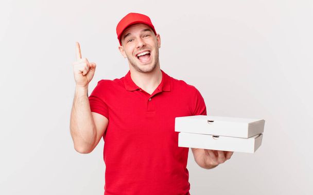 pizza deliver man feeling like a happy and excited genius after realizing an idea, cheerfully raising finger, eureka! - Zdjęcie, obraz