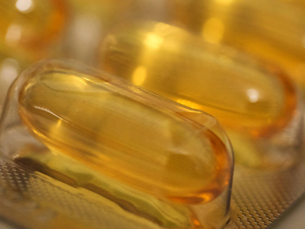 Balíček žlutých pilulek, vyfocených zblízka. Léčivý přípravek, makro. - Fotografie, Obrázek