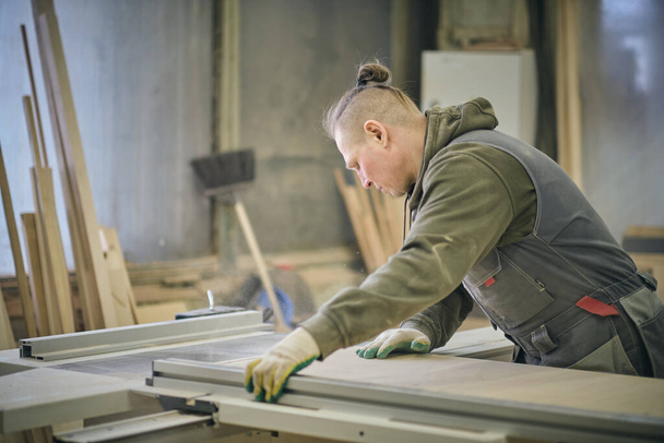 Houtwerk en meubelmakerij. Joinery, houtbewerking en meubelmakerij, professionele timmerman hout snijden in timmerwerk winkel, industrieel concept. - Foto, afbeelding