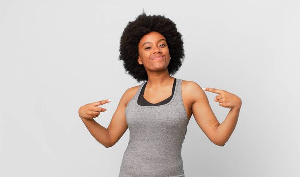 black afro woman looking proud, arrogant, happy, surprised and satisfied, pointing to self, feeling like a winner - Φωτογραφία, εικόνα