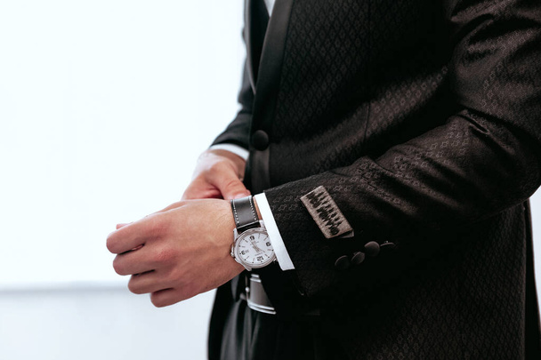 A closeup shot of a young male fixing his watch on his hand - Foto, Imagem