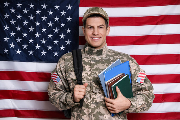 Cadet with backpack and books against American flag. Military education - Foto, immagini