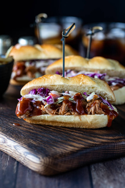 Three pulled pork sliders in a row ready for eating with cola beverages in behind. - Photo, Image
