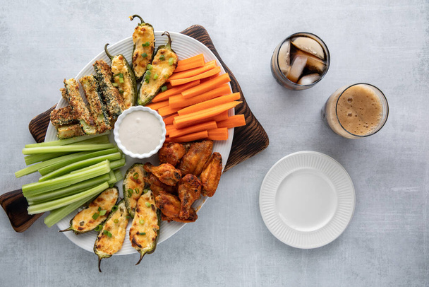 Top down view of an appetizer platter surrounded by plates and cola beverages ready for snacking. - Photo, Image