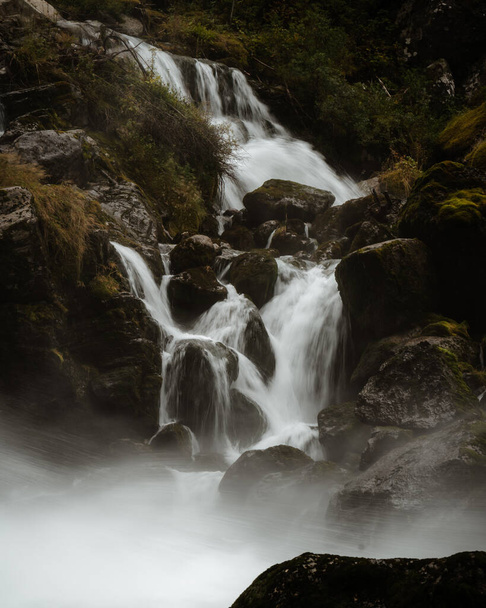 A vertical shot of a waterfall on the mountains - Foto, Imagen