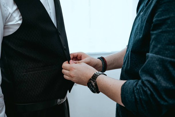 A closeup shot of a male helping a groom to dress up - Fotoğraf, Görsel