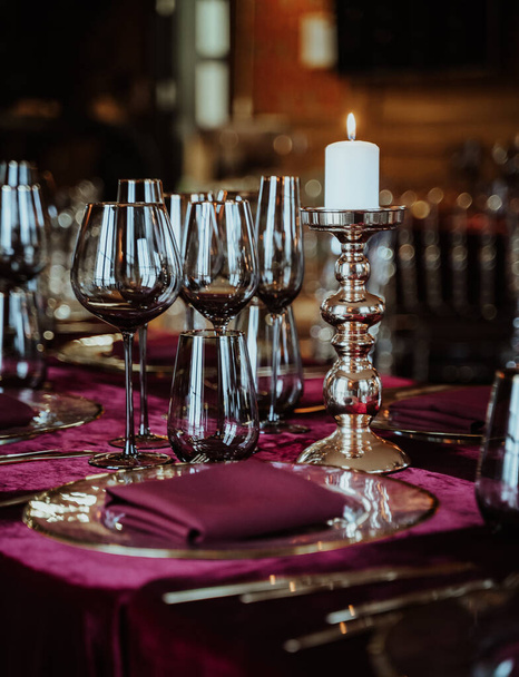 A vertical shot of an elegant dinner table decoration with candles and flowers - Foto, immagini