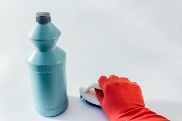 Продукти для чищення пляшка, рука в рукавичці тримає пензлик на світлому фоні
. - Фото, зображення