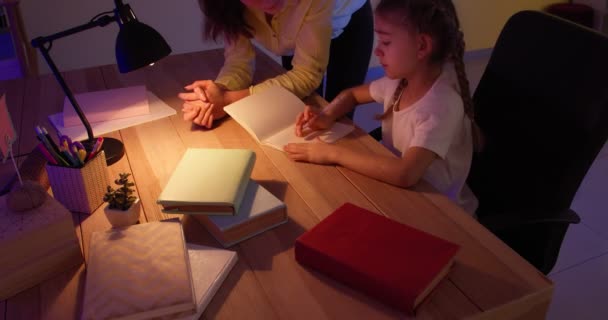 Madre arrabbiata rimprovera la sua piccola figlia per errore nei compiti a casa a tarda sera - Filmati, video