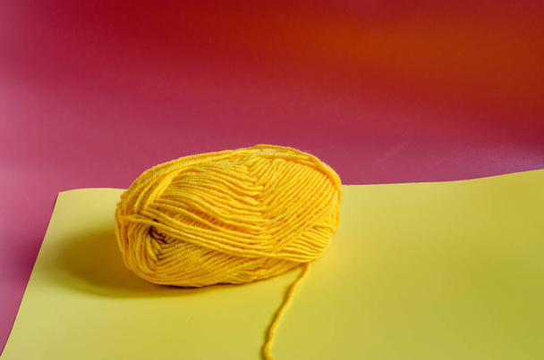 skein of yellow yarn on a colored background close-up knitting in self-isolation - Photo, image