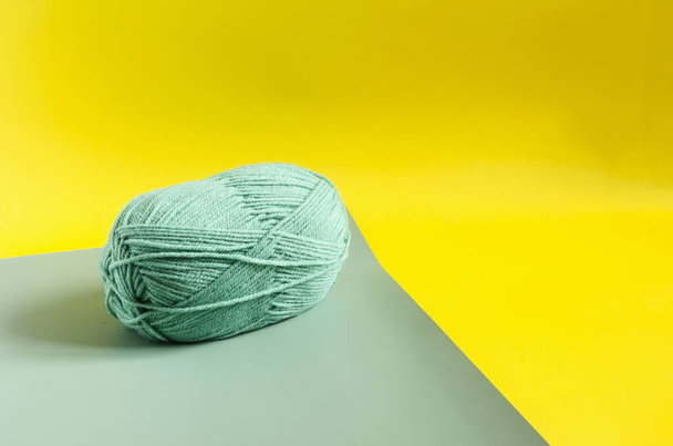 a skein of green yarn on a colored background close up knitting in self isolation - Zdjęcie, obraz