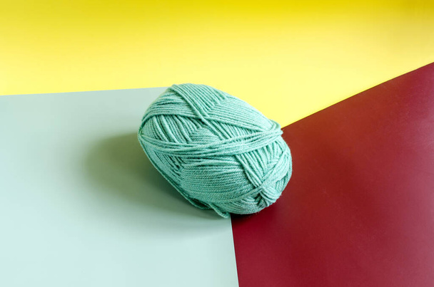a skein of green yarn on a colored background close up knitting in self isolation - Photo, image