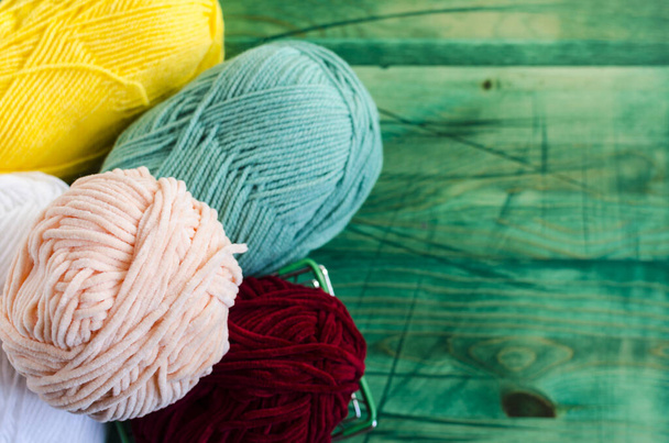 skeins of colored yarn, on a colored wooden background top view blurred background knitting concept - Photo, image