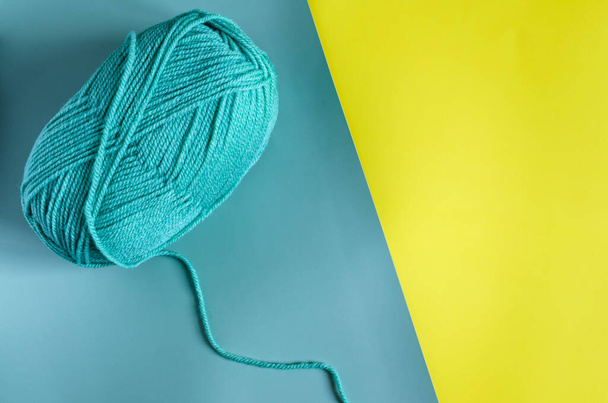 skein of green yarn on a two-tone yellow-green background background top view place for text - Zdjęcie, obraz
