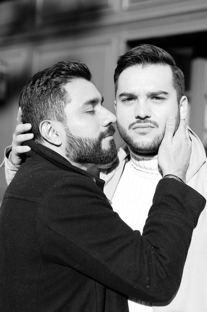 Black and white photo of young hugging and kissing gays. - Zdjęcie, obraz