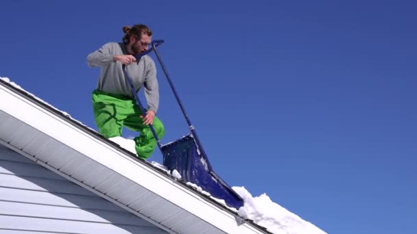 Güneşli bir kış gününde taze karı çatıdan kaldırıyorum. - Video, Çekim