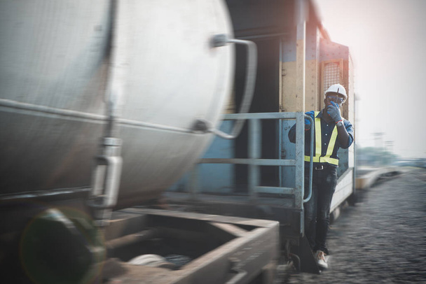 Afrikanischer Ingenieur hält Funkverbindung oder Walkie Talkie und hängt aus dem Zug - Foto, Bild