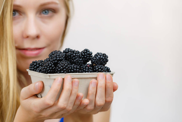 Woman holding fresh blackberry fruits in paper box. Healthy seasonal fruit, organic nutrition. - Foto, Bild