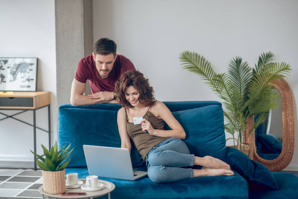 Couple making periodical payments online and looking involved - Φωτογραφία, εικόνα