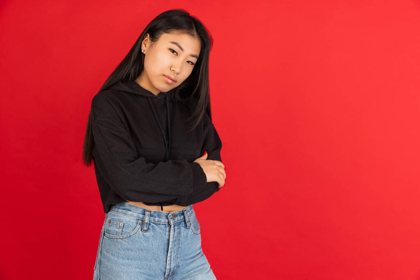 Ázsiai fiatal lányok portré elszigetelt piros stúdió háttér. Retro stílus - Fotó, kép