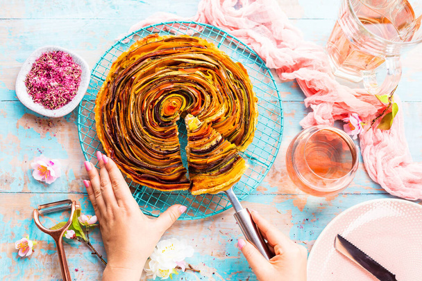 partial top view of female hands and delicious spiral vegetable tart  - Foto, Imagem