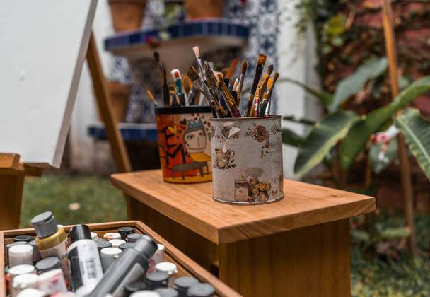 木製のベンチに瓶や画家のツールでブラシをペイント - 写真・画像