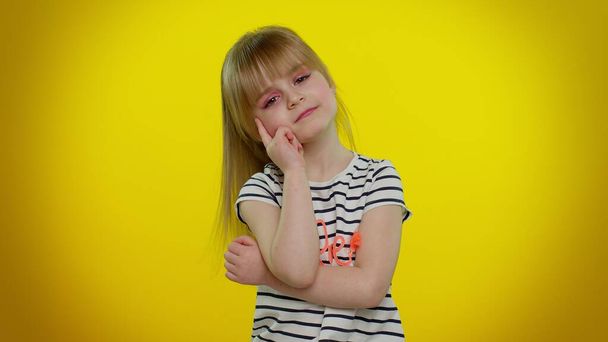 Nachdenkliche clevere kleine Teenie-Kind Kind Mädchen reibt sich das Kinn und überlegt eine Lösung zweifelhafte Frage - Foto, Bild
