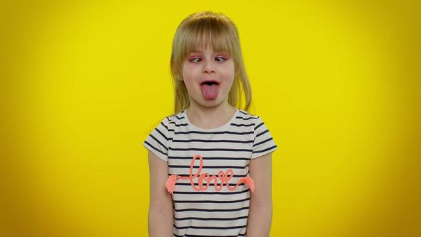 Забавна дівчинка-дитина робить грайливі дурні вирази обличчя і похмурість, обман, показуючи язик
 - Фото, зображення