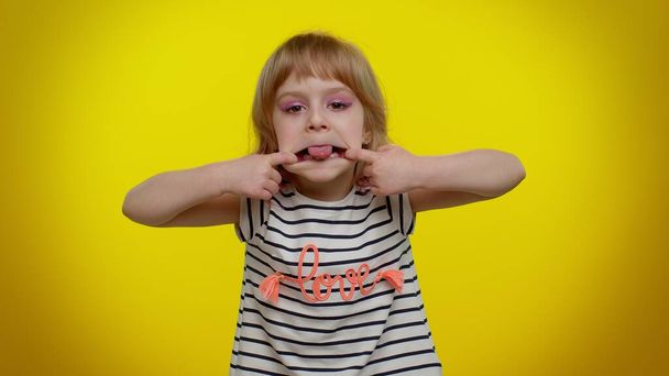 Dítě dívka ukazující jazyk dělat obličeje na kameru blbnutí kolem vtipkování s hloupé obličeje škádlení - Fotografie, Obrázek