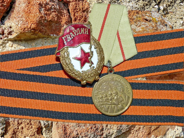 La medaglia "Per la difesa di Stalingrado" e un segno di "Guardie" sullo sfondo del nastro di San Giorgio. Un cimelio. Memoria. 9 maggio - Giorno della Vittoria.  - Foto, immagini