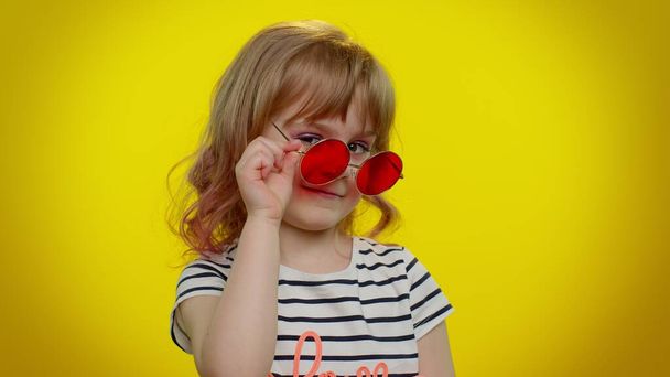 Divertente bambino biondo giocoso con gli occhiali da sole, occhio lampeggiante, guardando con sorriso affascinante - Foto, immagini