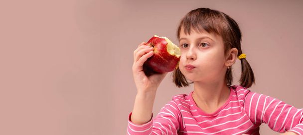 It's really tasty and healthy food! Young beautiful girl eating apples. Copy space for design.  - Fotografie, Obrázek