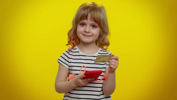 Kis tini gyerek gyermek lány hitelkártyával és okostelefonnal vásárlás közben online vásárlás - Fotó, kép